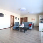 svetainė su skandinavišku židiniu ir aukštomis lubomis