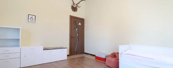 miegamasis su aukštomis lubomis ir medinėmis grindimis