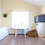 miegamasis su aukštomis lubomis ir medinėmis grindimis