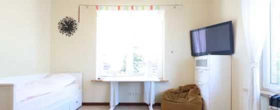 miegamasis su aukštomis lubomis ir medinėmis grindimis